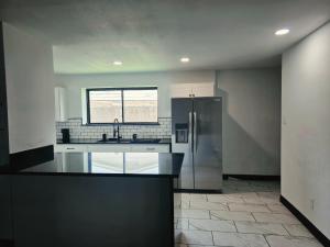 an empty kitchen with a refrigerator and a window at Alma House in Corpus Christi
