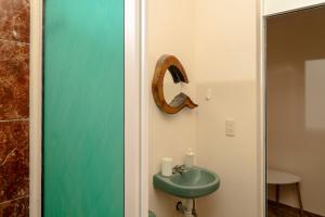 a bathroom with a green sink and a mirror at Montero Residences in Brisas de Zicatela +40 photos