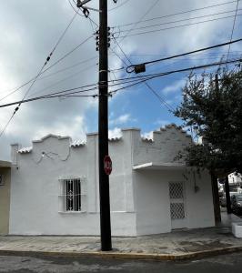 a white house with a stop sign in front of it at Deluxe noir Loft cerca de parque fundidora in Monterrey