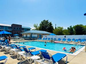 a swimming pool with blue chairs and people in it at Put-in-Bay Waterfront Condo #207 in Put-in-Bay