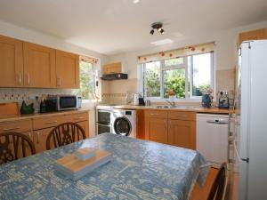 a kitchen with wooden cabinets and a table in it at Shepherd's Cottage in Bridgnorth