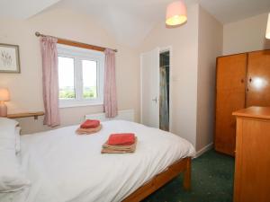 a bedroom with a bed with towels on it at Shepherd's Cottage in Bridgnorth