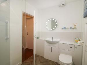 a white bathroom with a toilet and a sink at Shepherd's Cottage in Bridgnorth +17 photos