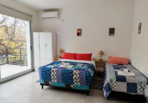 a bedroom with two beds and a large window at Casa Arpy in Mendoza