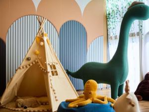 a childs room with a dinosaur tent and stuffed animals at Mercure Xi'an Daming Palace in Xi'an