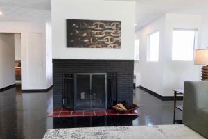 a living room with a fireplace with a painting on the wall at Alaskan Hideaway | Cozy & Adventure-Ready in Anchorage