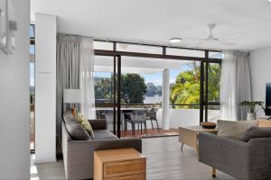 a living room with two couches and a table at The Noosa Apartments in Noosa Heads