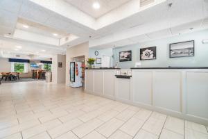 a large room with a kitchen with white cabinets at The Windstar Hotel - Emerald Isle, Swansboro in Cedar Point