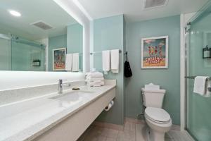 a bathroom with a sink and a toilet and a mirror at The Windstar Hotel - Emerald Isle, Swansboro in Cedar Point