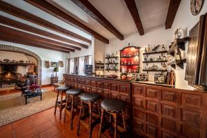 a bar with stools in a room with a fireplace at Herdade das Bernardas B&B in Vila Verde de Ficalho
