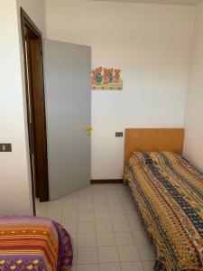 a bedroom with two beds and a door in it at Apartment with Pool in Rosolina Mare 57971 in Rosolina Mare +4 photos