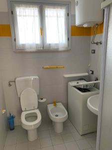 a small bathroom with a toilet and a sink at Apartment with Pool in Rosolina Mare 57971 in Rosolina Mare