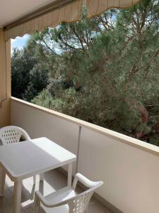 a white table and chairs on a balcony with a tree at Apartment with Pool in Rosolina Mare 57971 in Rosolina Mare