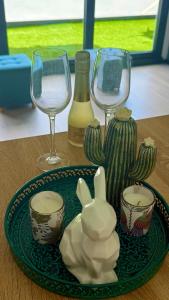 a table with two wine glasses and a plate with a bottle at La Terraza del Àtico con parking incluido in Vigo