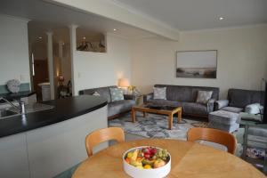 a kitchen and living room with a bowl of fruit on a table at Spectacular Views, Convenient, Affordable - KK17129 in Kaikoura +10 photos