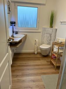 a bathroom with a sink and a toilet and a window at Paganetti´s Chalet in Breitscheid +30 photos