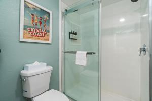 a bathroom with a toilet and a glass shower at The Windstar Hotel - Emerald Isle, Swansboro in Cedar Point +4 photos