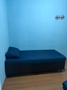 a bed in a room with a blue wall at Apto 2 qts em Xerém próximo ao CT do Fluminense in Duque de Caxias +18 photos