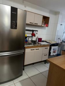 a kitchen with a stainless steel refrigerator at Apto 2 qts em Xerém próximo ao CT do Fluminense in Duque de Caxias