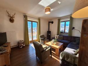 a living room with a blue couch and a table at Chalet with Mountain View in Piesendorf