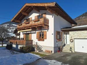 a house with wooden balconies on the side of it at Chalet with Mountain View in Piesendorf