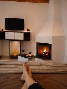 a person laying on a bed in front of a fireplace at Chalé Luar da Serra in Camanducaia