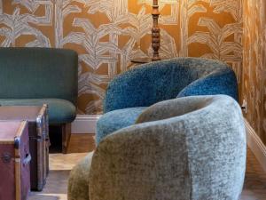 a living room with two chairs and a table at greet Hotel Chatellerault in Châtellerault
