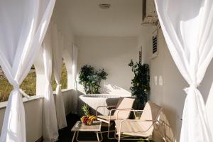 a balcony with white curtains and a table and chairs at Villa Grubešić - Sea View Apartments in Kustići
