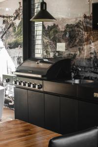 a kitchen with a stove and a sink at Softfoot Farm Luxury Retreats in Hindmarsh Valley
