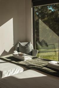 a bedroom with a bed and a window and a chair at Softfoot Farm Luxury Retreats in Hindmarsh Valley