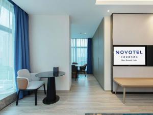 a lobby with a table and chairs and a sign at Novotel Wuxi in Wuxi +100 photos
