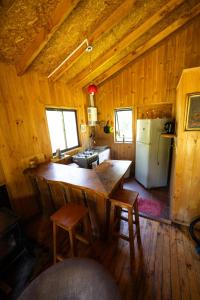 a kitchen with a large wooden table and a refrigerator at Rio liucura cabañas in Collentañe