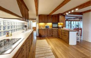 a large kitchen with wooden cabinets and a counter top at Villa Kalle in Åstorp