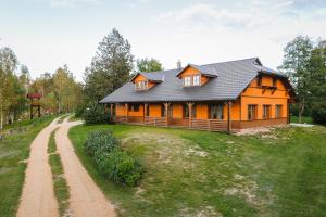 a house on a hill with a dirt road in front of it at Paegli Guest house in Kaijciems +11 photos