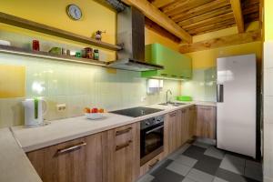 a kitchen with wooden cabinets and a white refrigerator at Paegli Guest house in Kaijciems