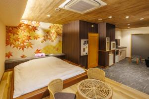 a bedroom with a bed and a table and chairs at HOTEL Lien in Ashiya