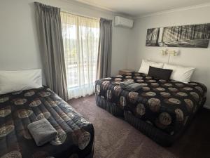 a hotel room with two beds and a window at Barwon Valley Lodge in Geelong