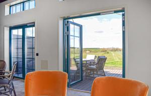 a patio door with chairs and a table on a deck at Beautiful Home In Kivik in Kivik