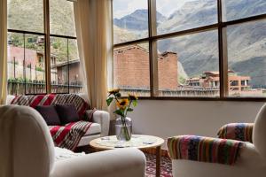 a living room with couches and a large window at Colibri Wasi Pisac in Cusco