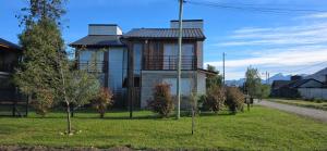 a house on the side of a grassy yard at Origen Rent a house in El Bolsón