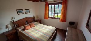 a bedroom with a bed and a table and a window at COMPLEJO LLATANI in Los Reartes +48 photos