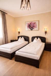 two beds in a hotel room with at Transylvania Villa & Spa in Gosau