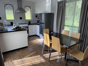a kitchen with a table and chairs and a refrigerator at Barwon Valley Lodge in Geelong