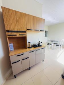 a kitchen with white cabinets and a table and chairs at Flat Vila Mariana in Tianguá