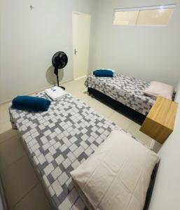 a room with two beds and a fan at Flat Vila Mariana in Tianguá
