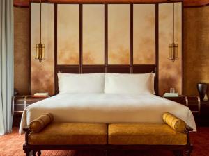 a bedroom with a large bed with a bench in it at Orient Express La Minerva in Rome
