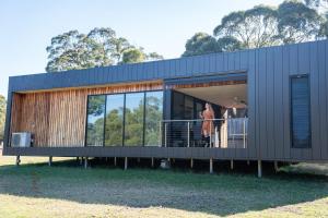 a rendering of a house with people standing on a balcony at Softfoot Farm Luxury Retreats in Hindmarsh Valley