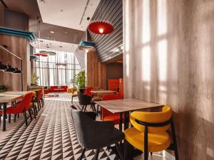 a restaurant with tables and chairs in a room at ibis Tbilisi City in Tbilisi City