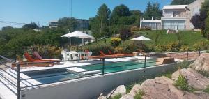 a swimming pool with chairs and umbrellas on a house at Balcón a las sierras - Cervantes 273 - La Falda in La Falda