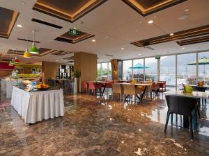 a dining room with tables and chairs and windows at Mercure Tai'an Centre in Tai'an